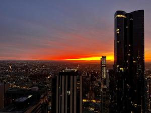 a view of a city skyline at sunset at Ruckers Hill Northcote Penthouse in Melbourne