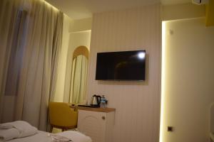 um quarto de hotel com uma televisão na parede em IMMYS em Seferihisar