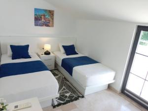 a bedroom with two beds and a desk and a window at Stone House Aparts Dublex 3 plus1 mit Meerblick und Jakuzzi Kalkan No 6 in Kas +24 photos