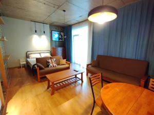 uma sala de estar com um sofá e uma mesa em Davka Apartments em Batumi