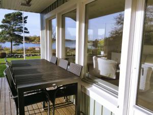 una veranda riparata con tavolo e sedie di Seaside Home with Stunning Views Overlooking Blekinge Archipelago a Ronneby