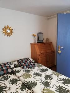 a bedroom with a bed and a dresser and a blue door at La casita linda in Eberbach