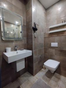 uma casa de banho com um lavatório, um WC e um espelho. em Davka Apartments em Batumi