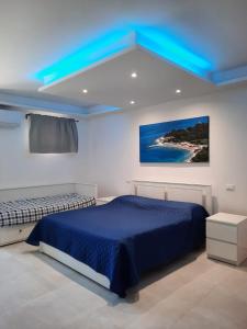 een slaapkamer met een bed en een blauw plafond bij IL CUORE DEL CONERO - CASALE CON PISCINA, Natura e Relax in Camerano