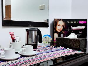 a counter top with cups and a coffee maker and a tea pot at west view hostel in ‘Ayn Amūn