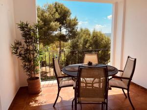a table and chairs on a balcony with a window at Arenal Dream Javea, luxury beach apartment in Jávea