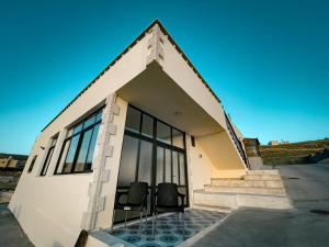 une maison avec deux chaises noires dans la porte dans l'établissement west view hostel, à ‘Ayn Amūn