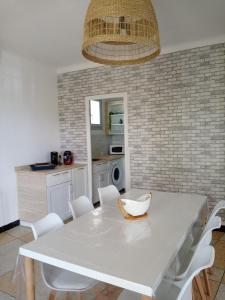 - une cuisine avec une table blanche et des chaises blanches dans l'établissement Les Abricots, à Tarascon
