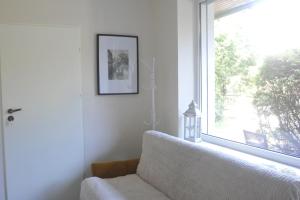 ein Wohnzimmer mit einem Sofa und einem großen Fenster in der Unterkunft Apartament Cristina in Mosty