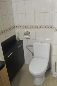 a bathroom with a white toilet and a black cabinet at Apartament Cristina in Mosty