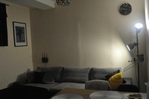 ein Wohnzimmer mit einem Sofa und einer Uhr an der Wand in der Unterkunft Apartament Cristina in Mosty