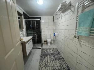 La salle de bains est pourvue d'une douche, de toilettes et d'un tapis. dans l'établissement Cayeli Kent Apart, à Cayeli