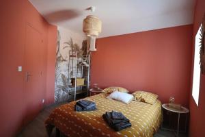 - une chambre avec un lit aux murs orange dans l'établissement Gîte Cottage, cosy entre terre et mer, à Vesly