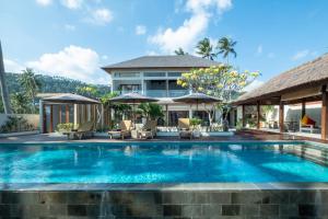 a swimming pool in front of a villa at Kamana Beach House in Mangsit