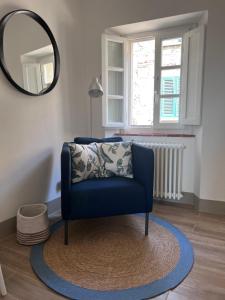une chaise bleue dans une pièce avec un miroir dans l'établissement O Nini! di Monteverdi Marittimo, Borgo di Canneto, à Canneto