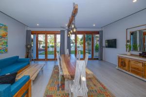 Kamana Beach House في مانغْسيت: غرفة معيشة مع طاولة خشبية وأريكة زرقاء
