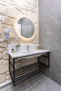 bagno con lavandino e specchio di Anna Mare Luxury Apartments ad Áfitos