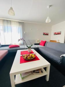 a living room with a table with a bowl of fruit on it at Apartmány Superrelax in Liptovský Mikuláš