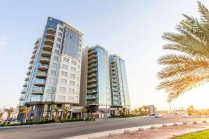 two tall buildings on a street with a palm tree at Chic/Elegant 4 Bedrooms… in Jeddah