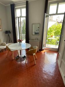 uma sala de estar com uma mesa e cadeiras e uma janela em Maison Dormoy em Marselha