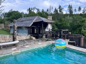 a swimming pool with a beach ball in front of a house at FarFar Hideaway in Tryavna