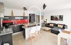 eine Küche und ein Wohnzimmer mit einem Sofa in der Unterkunft Côté Port-T3 Clim parking Wifi Plage By HC in Hyères
