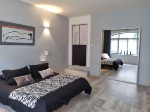 a bedroom with a large bed and a living room at Grand appartement près de la Cathédrale de Quimper in Quimper