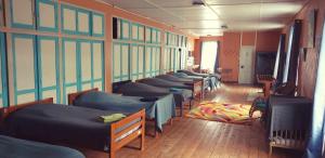 a row of beds lined up in a room at L'Eau Berge - Relais Motards - GTMC & Tour des Vaches B&B in Allanche