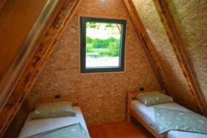 two beds in a small room with a window at Freedom in Forest in Jajce