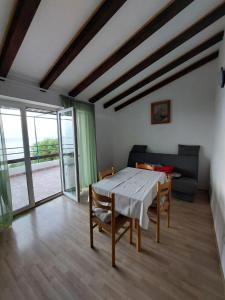 - une salle à manger avec une table, des chaises et un canapé dans l'établissement Apartmani Kapiton, à Hvar