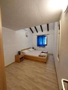 Cette grande chambre comprend un lit et une fenêtre. dans l'établissement Apartmani Kapiton, à Hvar