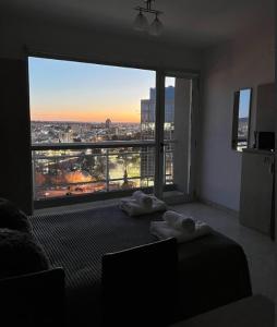 a bedroom with a large window with a view of a city at Monoambiente CENTRICO Neuquén Capital - ESPECTACULAR VISTA in Neuquén