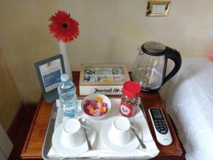 uma mesa com uma bandeja com comodidades para preparar café e uma cafeteira em B&B A Casa Mia em Pisa