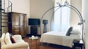 a bedroom with a bed and a chair and a tv at Hotel Palazzo Piccolomini in Orvieto