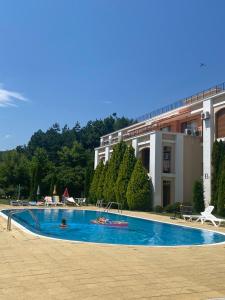 a swimming pool with two people swimming in it at Sea view apartment in Sveti Vlas in Elenite