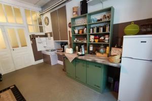 a kitchen with a white refrigerator and green cabinets at L'Eau Berge - Relais Motards - GTMC & Tour des Vaches B&B in Allanche