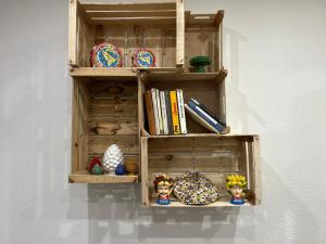 ein Holzregal an einer Wand mit Gegenständen darauf in der Unterkunft Casa Elivì Ballaró 2 passi dal centro storico, parcheggio e stazione ferroviaria in Palermo