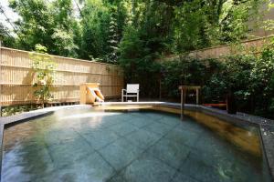 a swimming pool in a backyard with a wooden fence at Fufu Atami in Atami