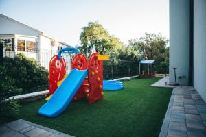 a backyard with a playground with a slide at Family apartment Mirjam in Orebić