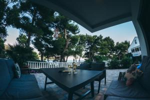 a patio with a black table and chairs and trees at Family apartment Mirjam in Orebić