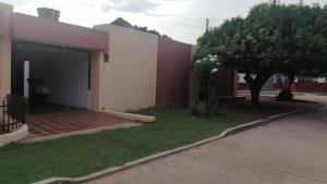 a house with a tree next to a building at Villa Myrian in Villanueva