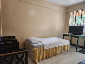 sypialnia z łóżkiem i biurkiem z komputerem w obiekcie Country Sampler Inn w mieście Tagaytay
