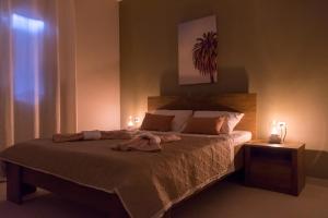 een slaapkamer met een bed met twee kaarsen erop bij Elegia Apartment in Mantoúkion
