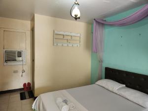 1 dormitorio con 1 cama con toallas en Country Sampler Inn, en Tagaytay