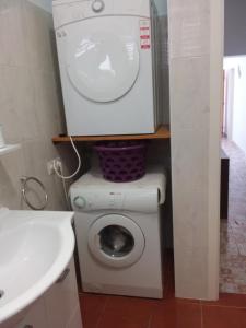 y baño con lavabo y lavadora. en Kiwi Nest, en Lumbarda