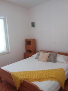 Un dormitorio con una cama con una manta amarilla. en Kiwi Nest en Lumbarda