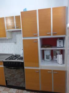 - une cuisine avec des placards en bois et une cuisinière dans l'établissement Kiwi Nest, à Lumbarda