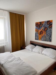 - une chambre avec un lit blanc orné d'une peinture murale dans l'établissement Apartment, à Francfort-sur-le-Main