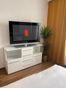 TV en una cómoda blanca en un dormitorio en Apartment, en Frankfurt