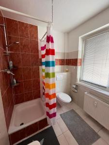a bathroom with a shower with a colorful shower curtain at Apartment in Frankfurt/Main
